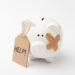 A white ceramic piggy bank with a bandage on its face and a cardboard tag that reads “HELP!” attached to its ear, set against a plain white background. | MyBestHub.com